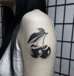 a black and white photo of two cherries with an umbrella tattoo on the arm