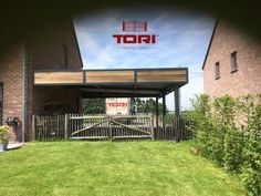 the front entrance to tori's restaurant in an open area with green grass