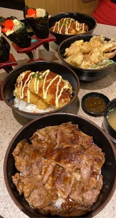 several plates of food on a table with sauces and condiments around them