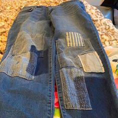 two pairs of jeans with patches on them