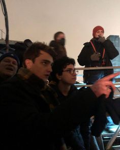 a group of young men standing next to each other in front of a camera man