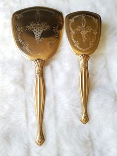 two golden serving utensils sitting on top of a white furnishing area