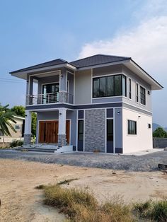 a two story house with lots of windows and balconies on the second floor