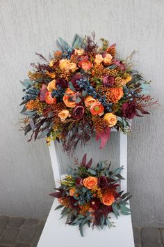 an arrangement of flowers sitting on top of a white chair