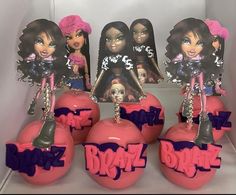 some pink and purple ornaments with barbie dolls on them