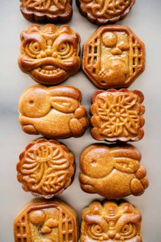 chinese mooncakes are arranged in rows on a white surface with the words happy written above them