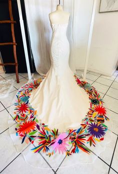 a wedding dress is displayed on a mannequin in front of a doorway with white tile flooring