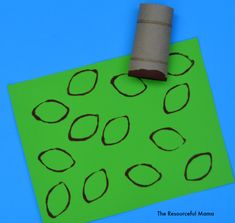 a roll of toilet paper sitting on top of a green piece of paper with circles drawn on it