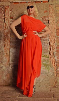 a woman in an orange dress poses for the camera with her hands on her hips