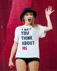 taylor swift performing on stage with her hands in the air and wearing a t - shirt that says, i bet you think about me