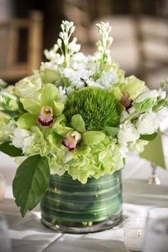 a vase filled with lots of green and white flowers