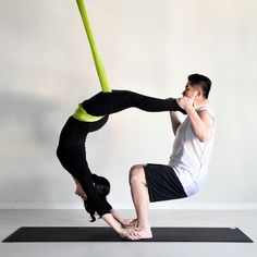 the man is practicing his aerial acrobatic yoga move with one leg in the air