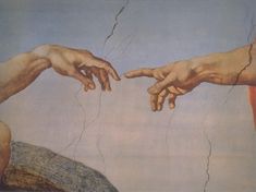 two hands reaching out to touch each other's fingers in front of a painting