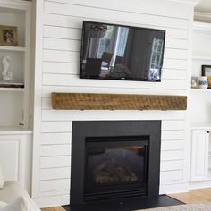 a television mounted on the wall above a fireplace