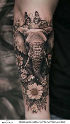 an elephant with flowers and butterflies on it's arm is shown in black and white