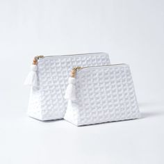 two white bags with tassels on them