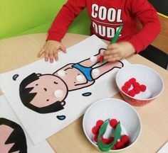 a young boy sitting at a table with paper cut outs