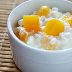 a bowl of oatmeal with oranges and yogurt in it