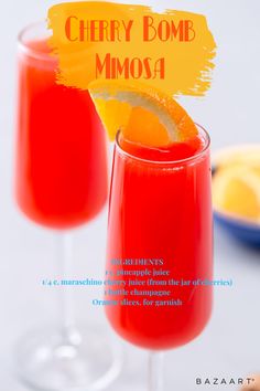 two glasses filled with red liquid and orange wedges on top of each glass,