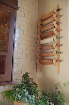 a wooden rack with rolling dough on it next to a potted plant and window