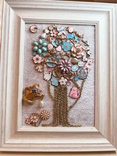 a white frame with a tree made out of buttons and other things in it,