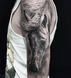 a man's arm with a horse tattoo on it, and the image is black and white