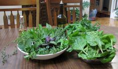 two bowls filled with greens on top of a wooden table