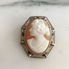 "14K white gold Small cameo. Very ornate, filigree setting holds a wonderful carved cameo of a beautiful Victorian women from the Edwardian era. This cameo can be both a brooch or a pendant. Brooch was made in the early 1900's and measures over 1 3/16\" in length X approximately 1\" in width. What makes this cameo so special is the fine detailed carving and wonderful delicate intricate frame, a tiny treasure. Shipping includes insurance. As always, local pickup is available. Aphrodite's Antique Classic Cameo Brooches For Wedding, Heirloom Cameo Brooch For Formal Occasions, Heirloom Style Cameo Brooch For Formal Occasions, White Cameo Brooch For Formal Occasions, Heirloom Cameo Brooches For Formal Occasions, White Cameo Brooches For Formal Occasion, White Ornate Brooch For Formal Occasions, Ornate White Brooches For Formal Occasions, White Ornate Brooches For Formal Occasions