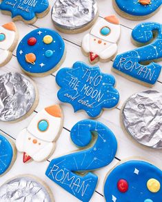 cookies decorated to look like the moon and rocket ship are for children's birthdays