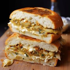 two grilled sandwiches stacked on top of each other with cheese and onions in the middle