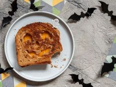 a piece of bread that has been cut in half on a plate with bats around it