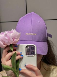 a woman taking a selfie with her cell phone and flowers in front of her