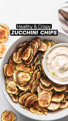 healthy and crispy zucchini chips in a white bowl with dip on top