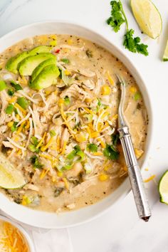 a bowl of chicken enchilada soup with avocado and cilantro