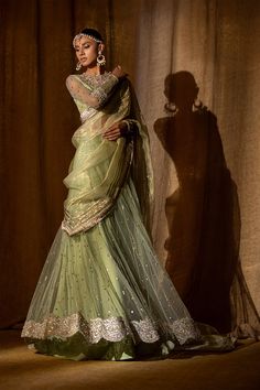 Indian Wedding Lehenga with Choli and Dupatta Dress is an elegant attire that wins everyone's hearts at the very first glance with its charm and beauty. Hand-crafted embellishments and luxury designs make this Lehenga Choli an epitome of grace and royalty. Net Choli The choli comes in an alluring Pista green color and is gracefully emblazoned with luxury details of mukaish, sequins, stones, and zardosi. The fabric of this choli is net. Intricate designs and silver gold work make this choli a per Tissue Dupatta, Shimmer Blouse, Pakistani Bridal Dress, Indian Wedding Lehenga, Pengantin India, Simple Lehenga, Bridal Dupatta, Green Lehenga, Pakistani Wedding Dress