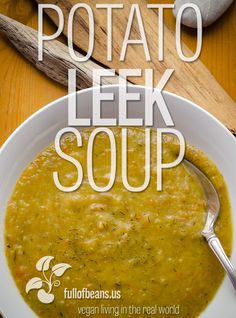 a bowl of potato leek soup on a wooden table with a spoon in it