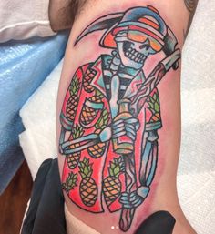 a man with a colorful tattoo on his arm holding a knife and pineapples