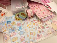 many different types of stickers and tape on top of a white table with other items