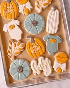 decorated cookies in the shape of baby clothes and pumpkins