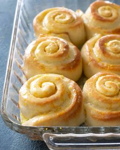 a glass dish filled with cinnamon rolls on top of a table