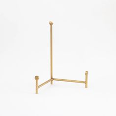 a pair of gold colored metal poles on a white background with no one in the photo