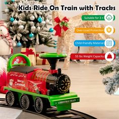 a toy train is on the tracks near a christmas tree