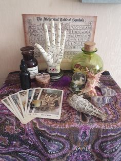 a table topped with lots of different items on top of a purple cloth covered table