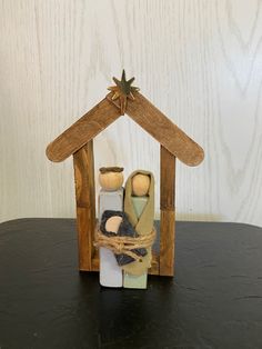 a nativity scene made out of wood on a table with a star above it