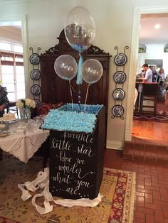 a table with balloons and a sign on it