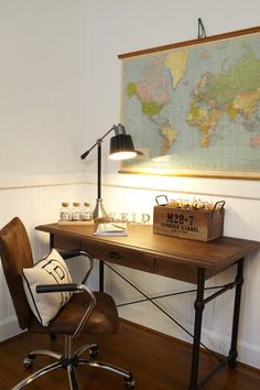 a desk with a map on the wall above it and a lamp next to it