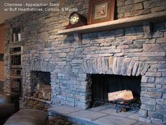 a stone fireplace in a living room with leather couches and a clock on the wall