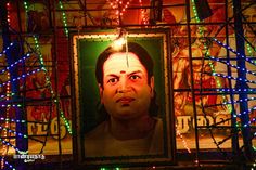 a man's face is lit up with christmas lights in front of a poster of him