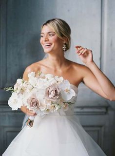 a woman in a white dress holding a bouquet of flowers