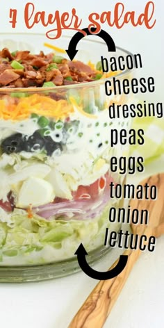 a layered salad with bacon, cheese and dressing